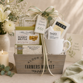 Gift basket with a mug, snacks, and cards on a neutral background