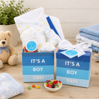 Baby shower gift set for a boy with candy, and baby items on a wooden surface.