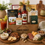 Gourmet gift basket with snacks, drinks, and charcuterie on a wooden table.